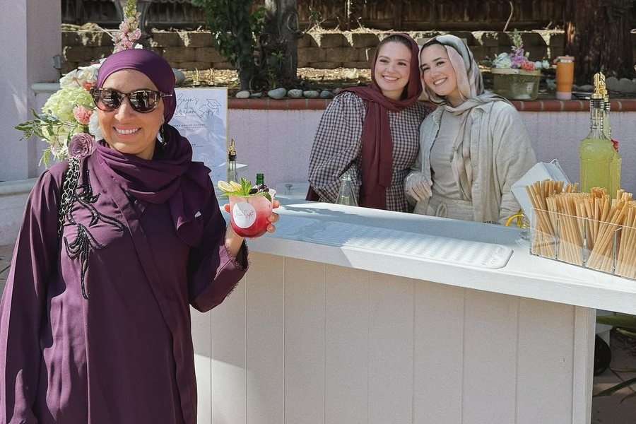 Guests with mocktails at the Clean Sips cart during a graduation celebration